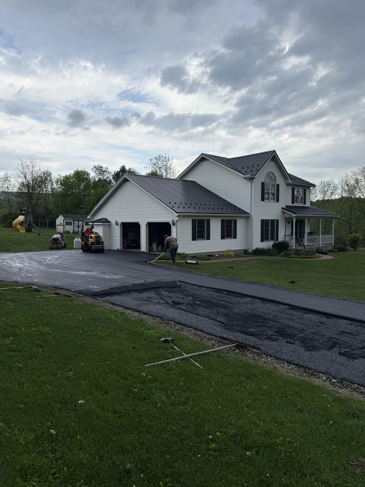 Asphalt driveway extending across the front of a home and garage