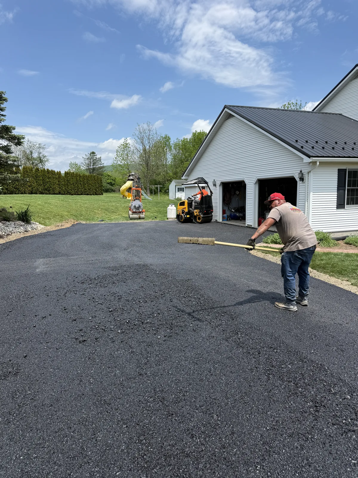 Our team spreading asphalt on a residential driveway