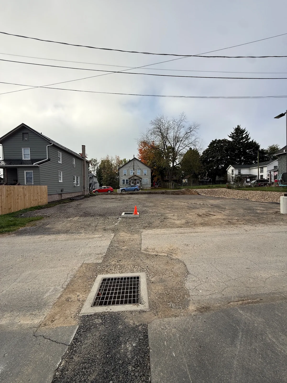 Existing parking area with a drainage grate in the foreground.