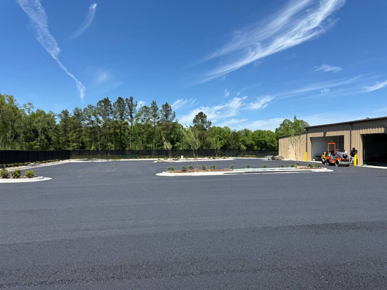 New asphalt parking area with landscaped islands at the Caliber Collision site in Denham Springs, Louisiana.