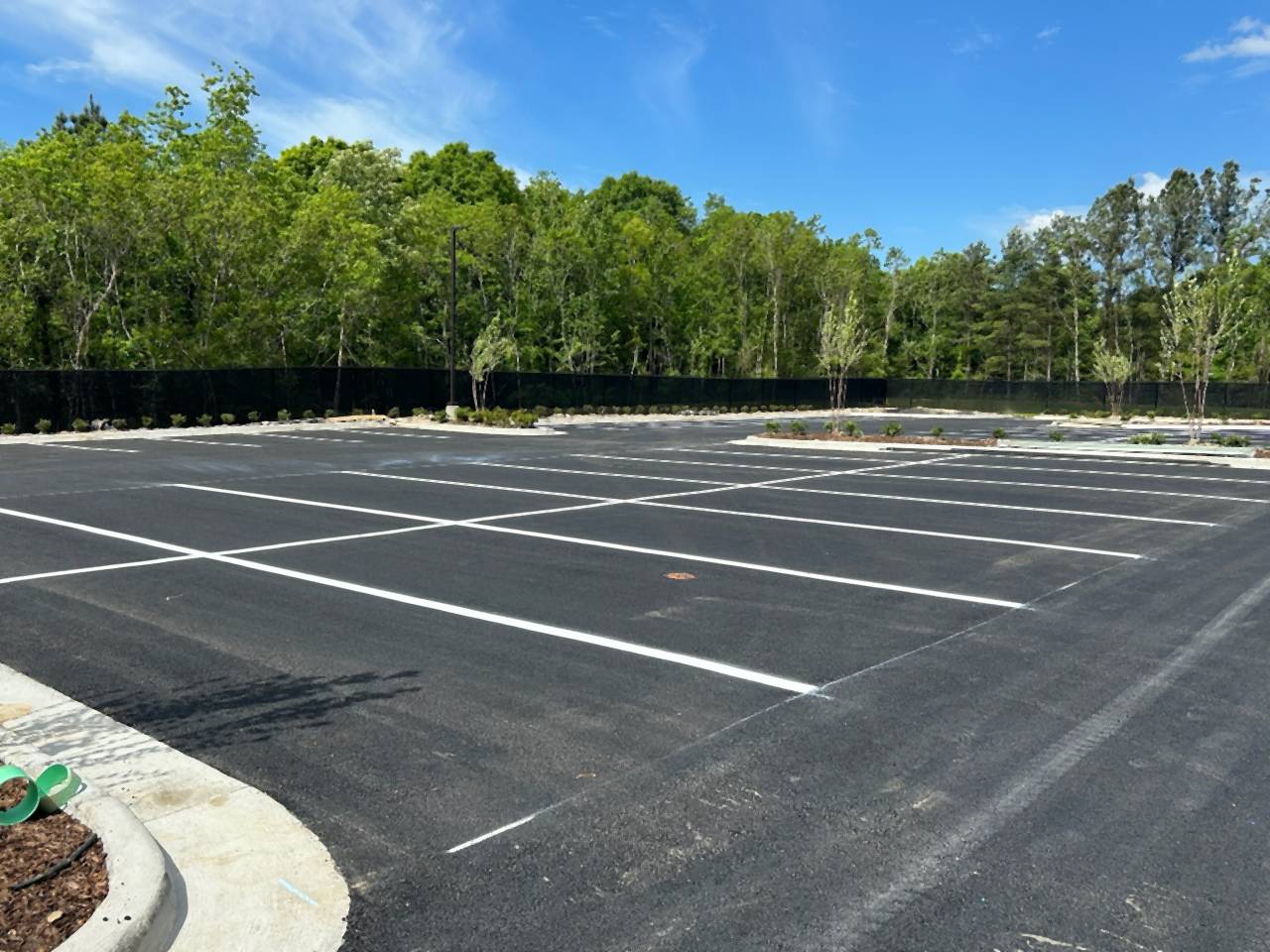 Newly striped parking stalls and curbed islands at the Caliber Collision new construction project in Denham Springs, Louisiana.