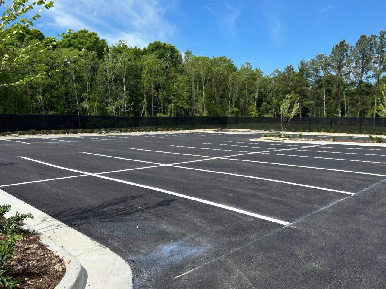 Striped stalls along a curbed island at the Caliber Collision new construction project in Denham Springs, Louisiana.