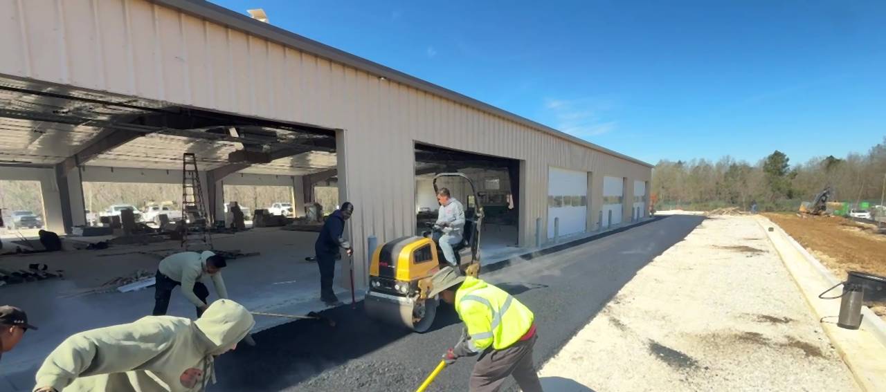 Our crew raking and rolling binder beside the building at the Caliber Collision new construction project in Louisiana.